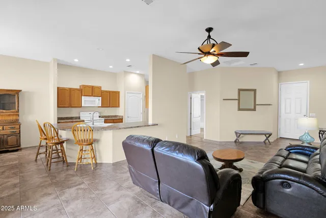 a living room with couches a coffee table and a piano with wooden floor