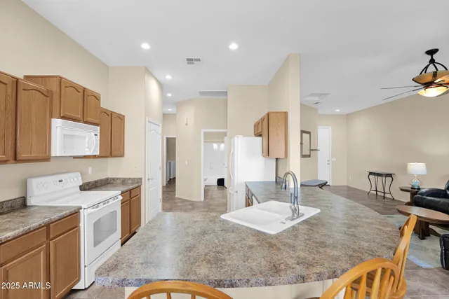 a large kitchen with kitchen island a sink a counter top space and stainless steel appliances