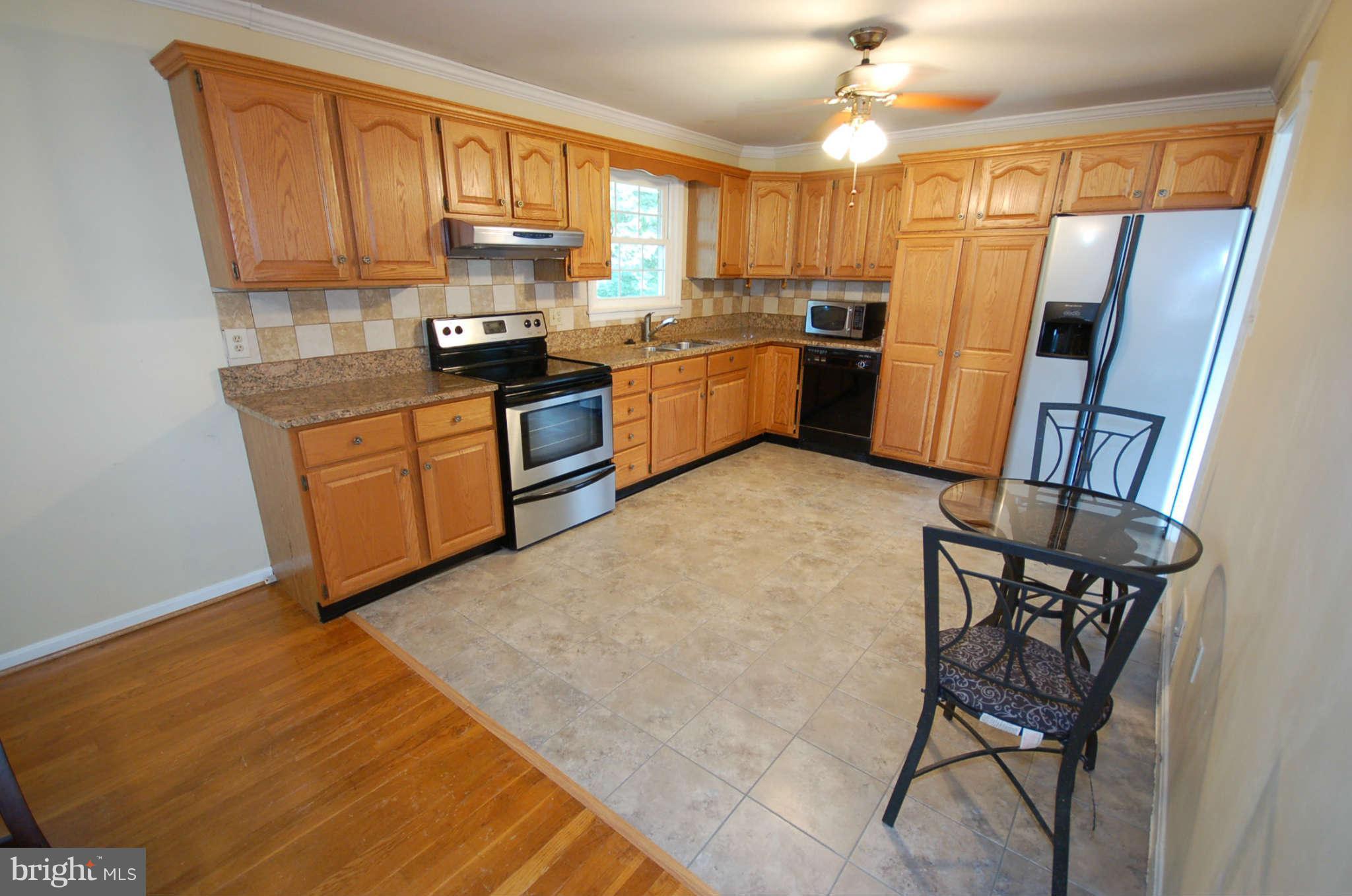 3132 Castleleigh Road Silver Spring, MD 20904 - Photo 6 of 25 a kitchen with stainless steel appliances granite countertop a refrigerator a stove a sink dishwasher and a microwave