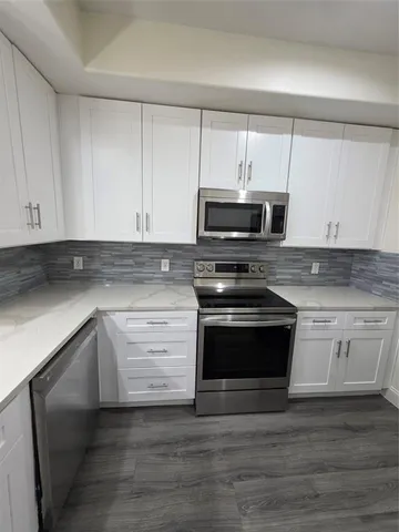 a kitchen with granite countertop a stove and a microwave