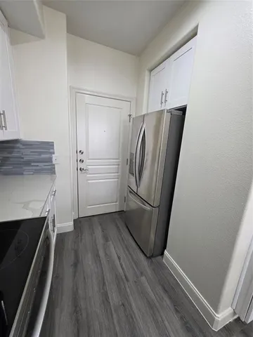 a view of kitchen with refrigerator and wooden floor