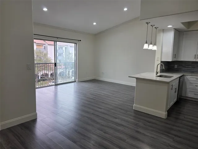a view of a kitchen with a sink and wooden floor