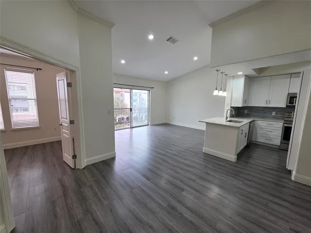 a kitchen with granite countertop a stove and a wooden floors