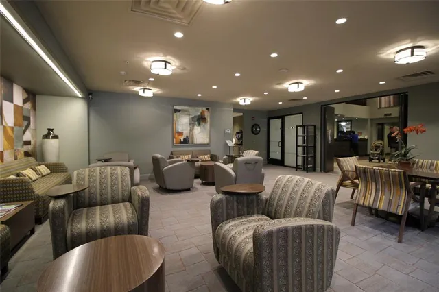 a living room with furniture and a view of kitchen