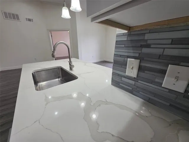 a kitchen with a sink and a stove top oven