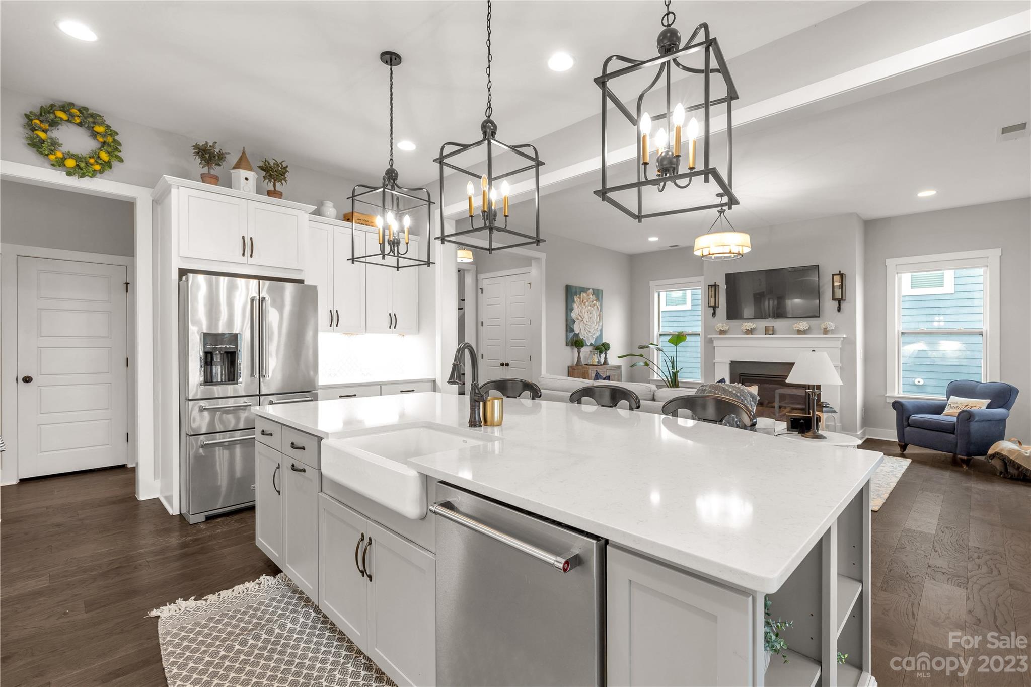 844 Bee Balm Trail Fort Mill, SC 29708 - Photo 15 of 48 a kitchen with stainless steel appliances a chandelier a kitchen island a stove a refrigerator a oven a dining table and chairs with wooden floor