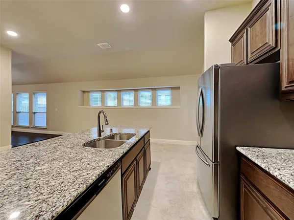 a kitchen with stainless steel appliances granite countertop a refrigerator a oven and a sink