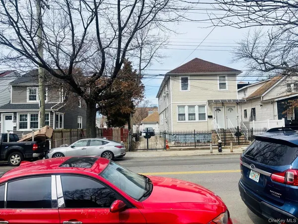 a front view of a building with cars parked