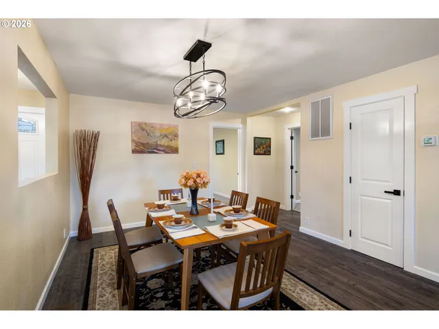 a view of a dining room with furniture a chandelier and wooden floor