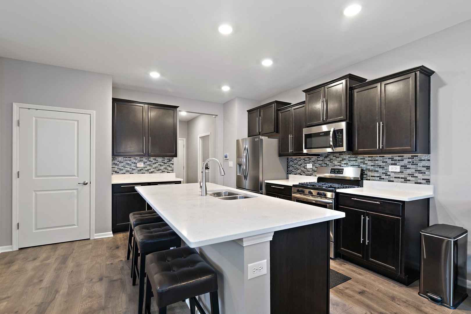 1979 Southern Circle, Unit 1979 Pingree Grove, IL 60140 - Photo 6 of 22 a kitchen with stainless steel appliances kitchen island granite countertop a sink a stove a refrigerator and island with wooden floor