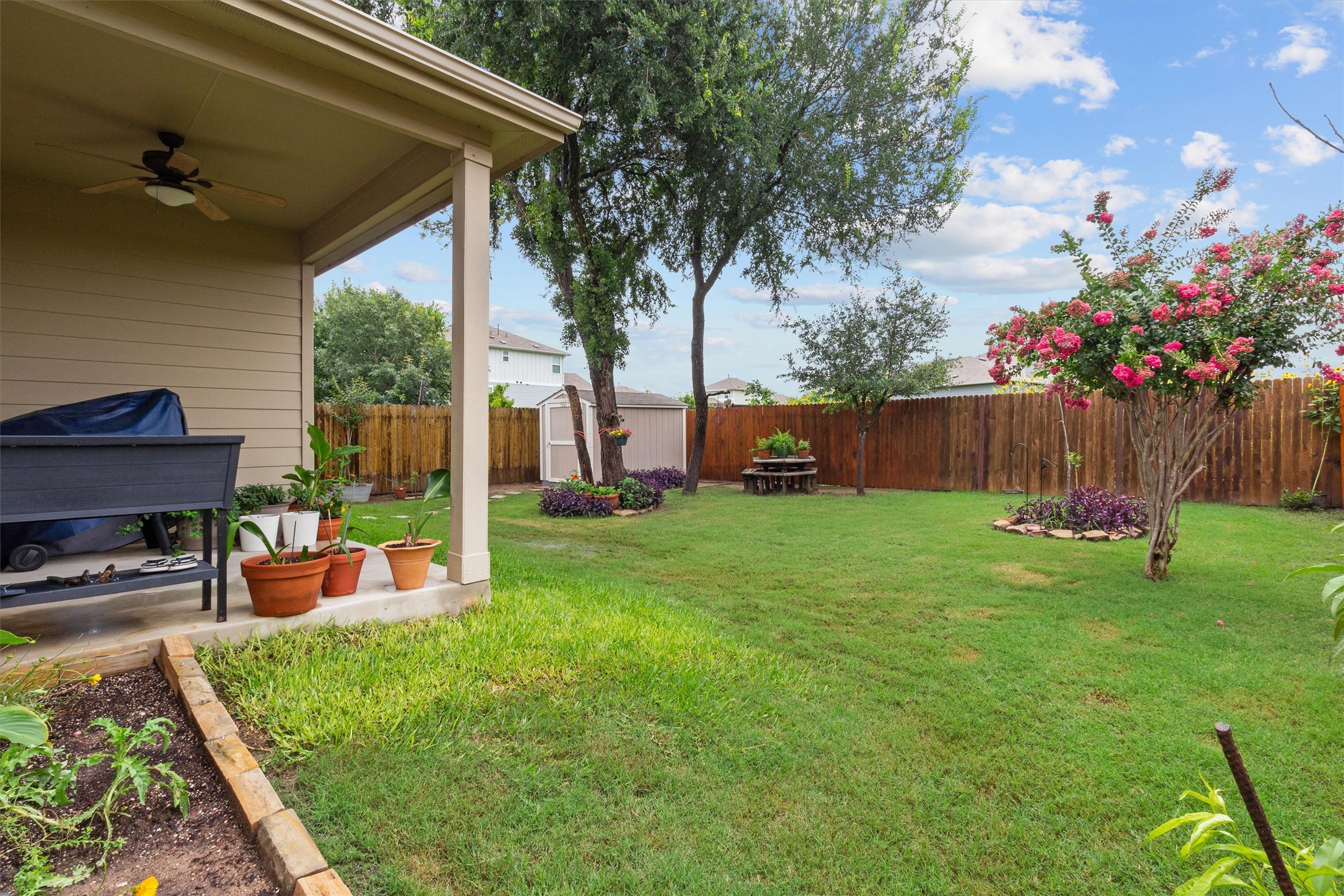 10413 Crescendo Lane Austin, TX 78747 - Photo 26 of 32 Relax in this fenced backyard oasis with a covered patio and ample green space for leisure.