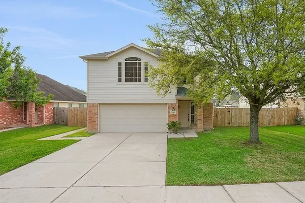a front view of a house with a garden and trees