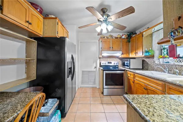 a kitchen with stainless steel appliances granite countertop a sink dishwasher stove and refrigerator