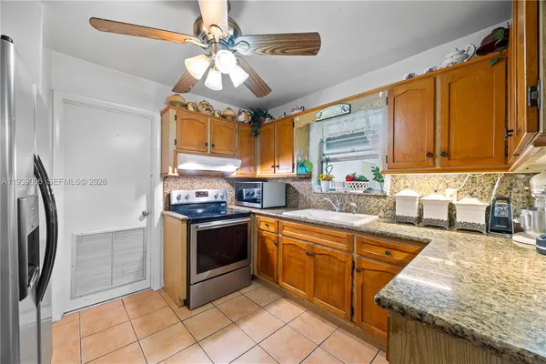 a kitchen with stainless steel appliances granite countertop a stove a sink dishwasher and a refrigerator