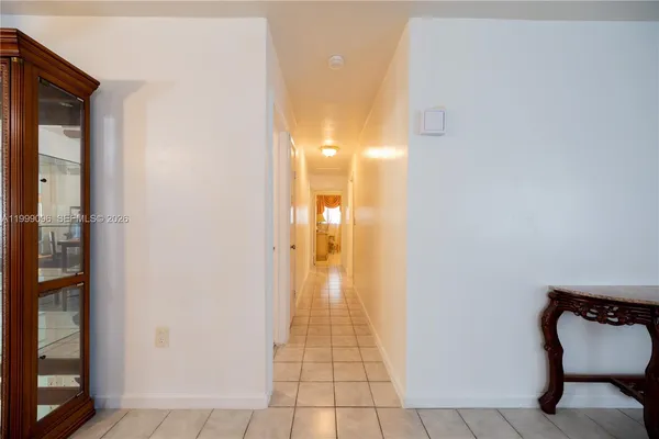 a view of a hallway with wooden floor and a bathroom