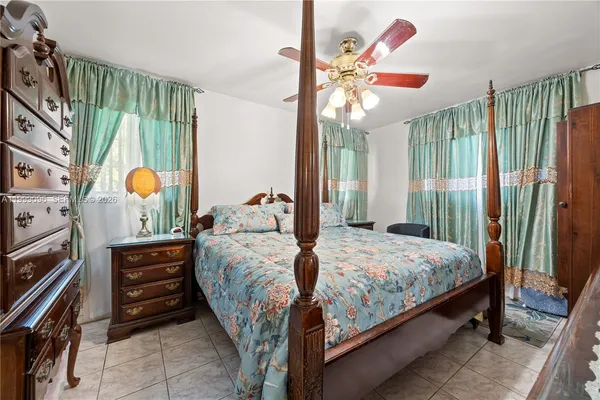 a bedroom with a bed a chandelier and a window