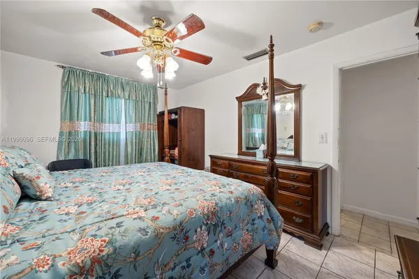 a bedroom with a bed dresser and a chandelier