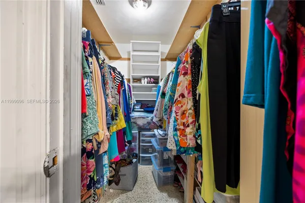 a view of walk in closet with clothes