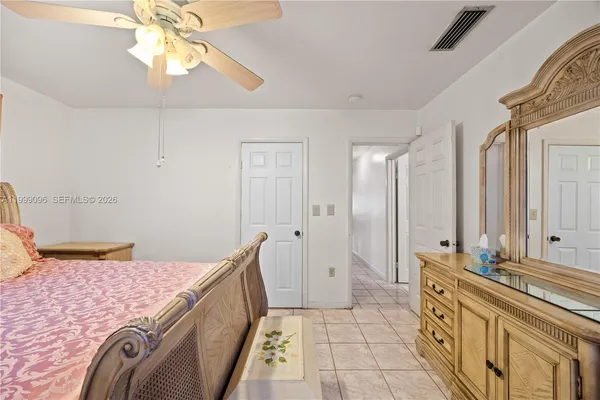a spacious bedroom with a bed and a chandelier