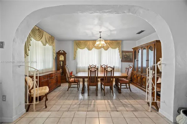 a dining room with furniture a chandelier and window
