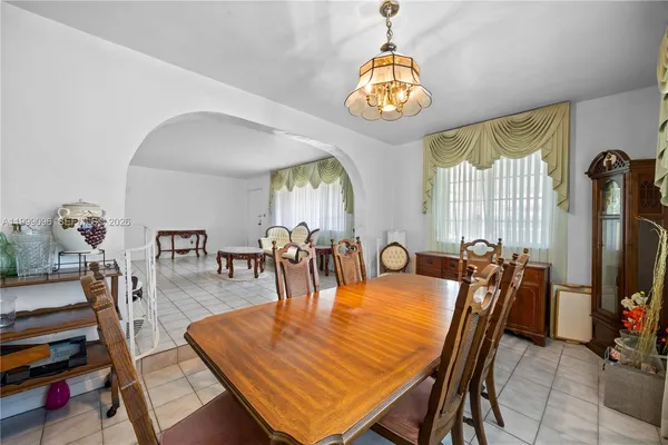 a dining room with furniture a chandelier and wooden floor