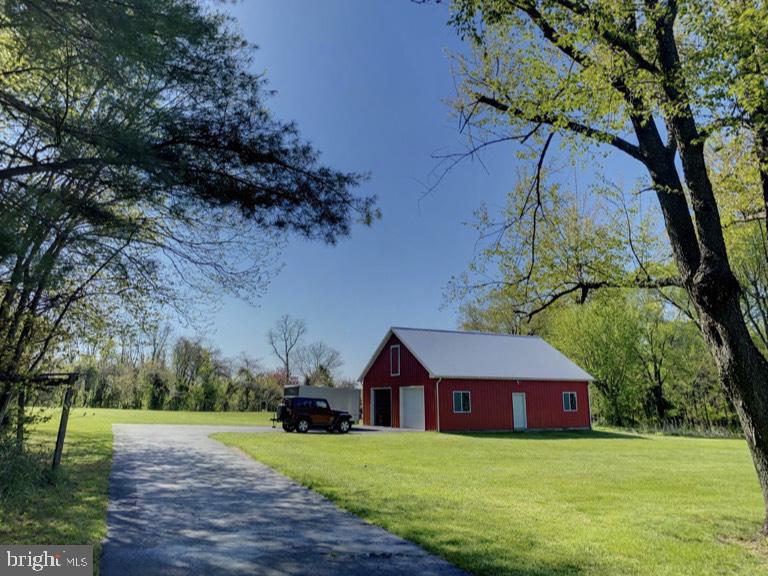 1670 Liberty Grove Road Conowingo, MD 21918 - Photo 6 of 18 Charming red barn amidst lush greenery.