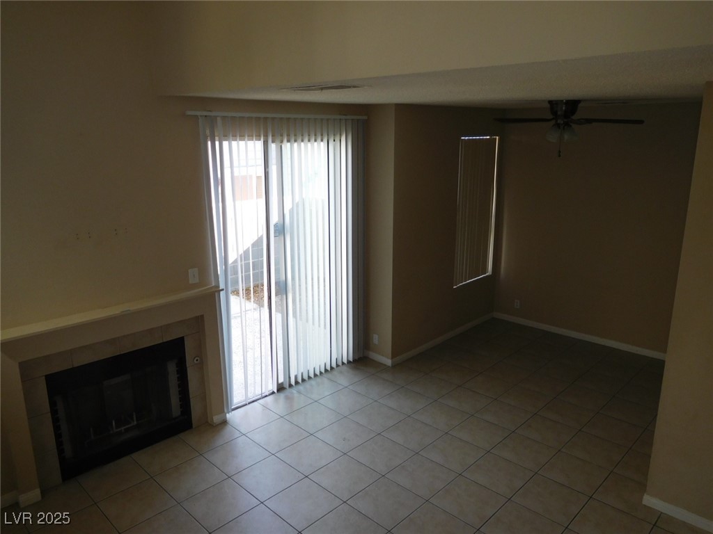 3220 Tocata Drive Las Vegas, NV 89146 - Photo 4 of 12 Unfurnished living room with a tiled fireplace, li