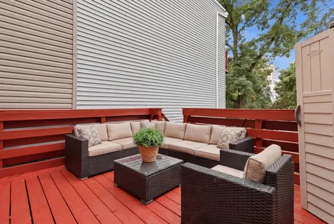 a view of a patio with couches and a potted plant on a wooden floor