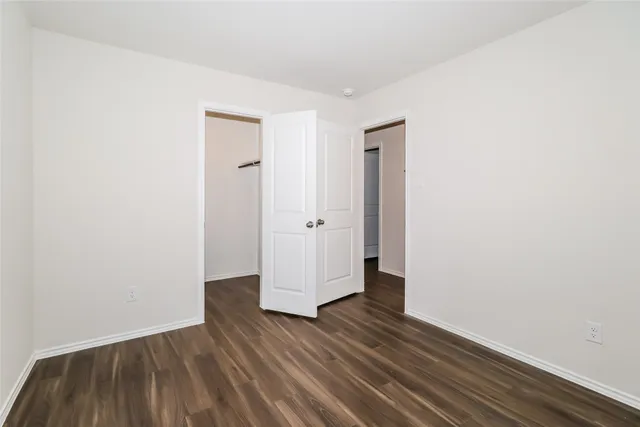 an empty room with wooden floor and wooden door