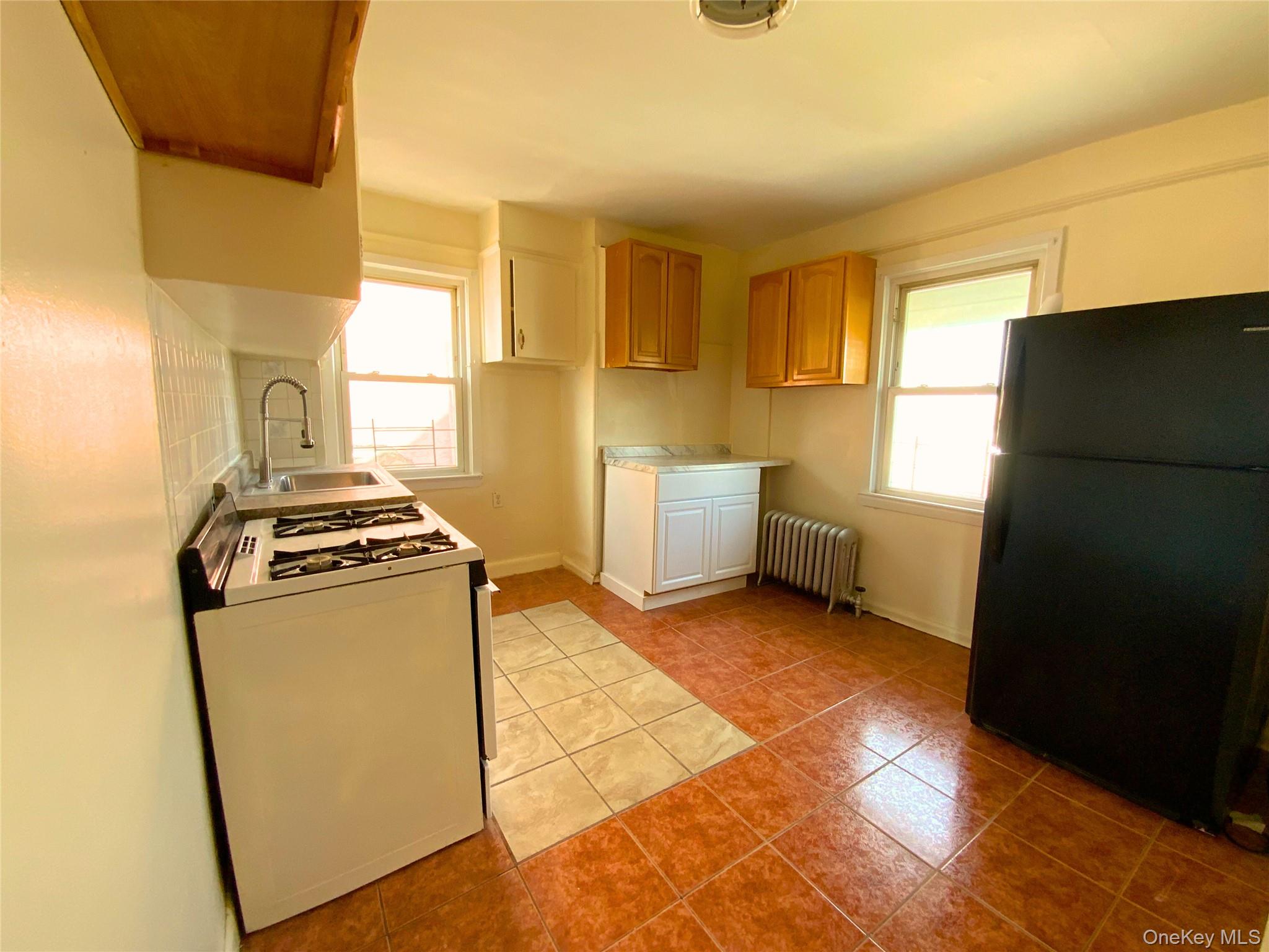 552 Beach 68th Street Queens, NY 11692 - Photo 24 of 34 a kitchen with granite countertop a refrigerator a stove and a sink