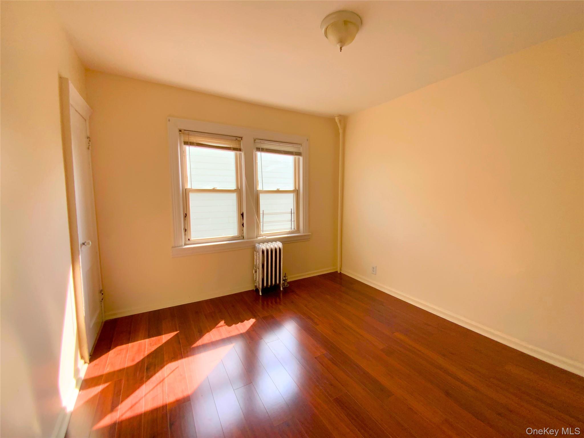 552 Beach 68th Street Queens, NY 11692 - Photo 30 of 34 an empty room with wooden floor and windows