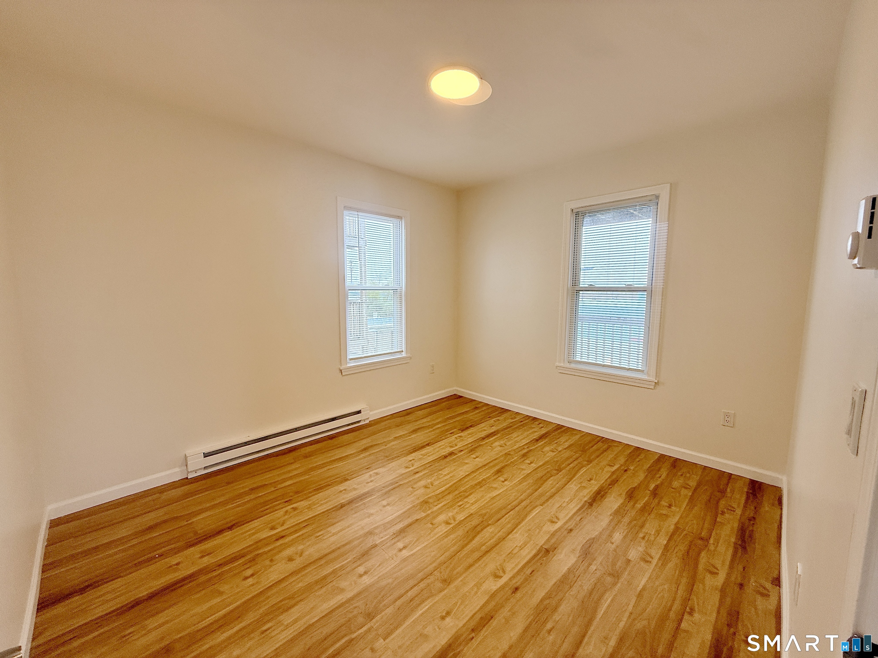 70 Lindley Street Bridgeport, CT 06604 - Photo 5 of 8 a view of empty room with wooden floor and fan