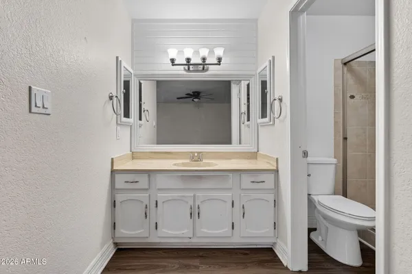 a bathroom with a granite countertop toilet a sink and a mirror