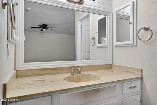 a bathroom with a granite countertop sink a mirror and shower