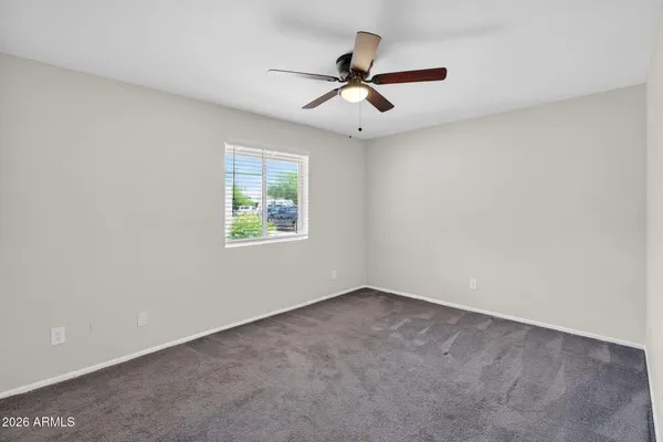 an empty room with a window and a fan