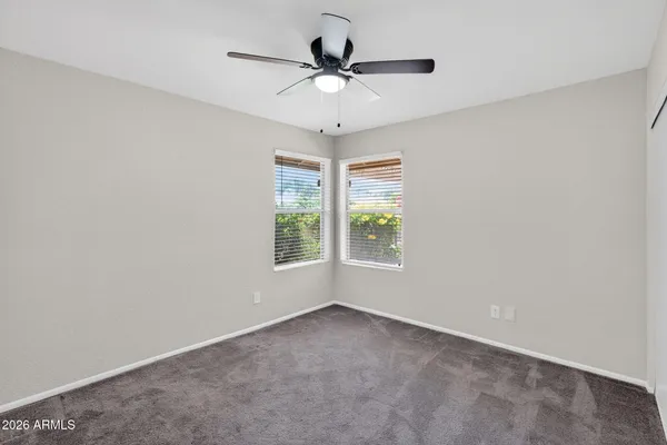 an empty room with a ceiling fan and window