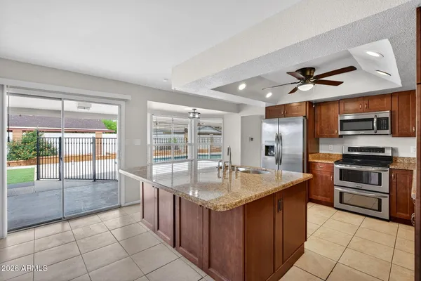 a kitchen with stainless steel appliances granite countertop a sink and a refrigerator