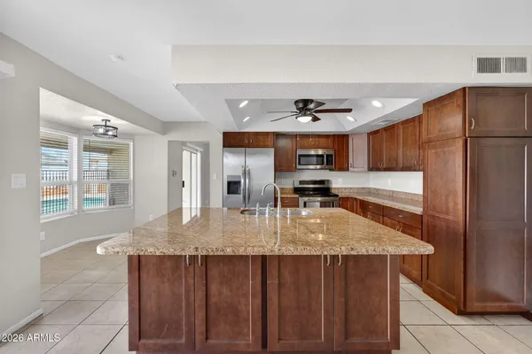 a kitchen with kitchen island a counter top space cabinets and stainless steel appliances