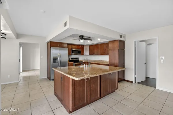 a kitchen with stainless steel appliances granite countertop a sink and a refrigerator