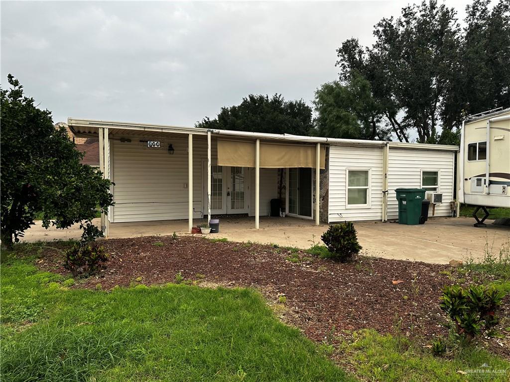 a view of a house with a backyard and a tree