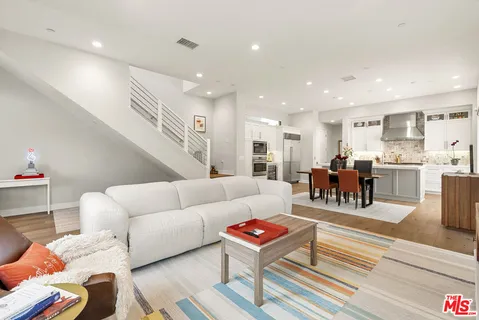 a living room with furniture and a dining table with kitchen view