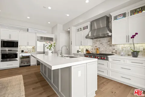 a kitchen with stainless steel appliances a sink stove and cabinets