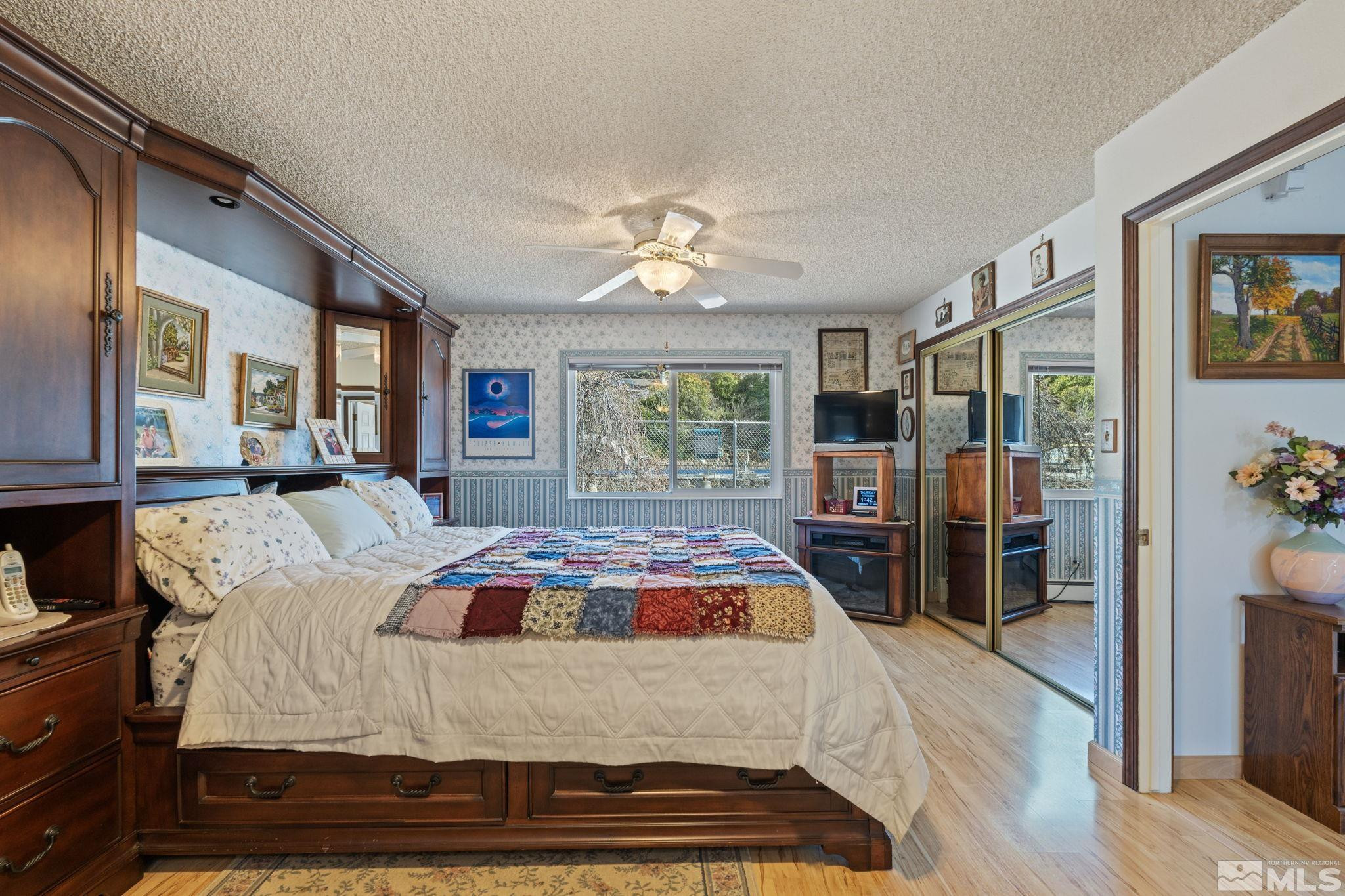 14440 Rim Rock Drive Reno, NV 89521 - Photo 24 of 39 a bedroom with a large bed and a chandelier