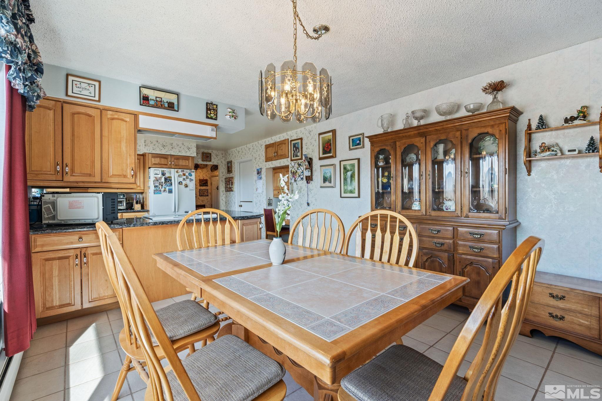 14440 Rim Rock Drive Reno, NV 89521 - Photo 4 of 39 a view of a dining room with furniture a chandelier and wooden floor