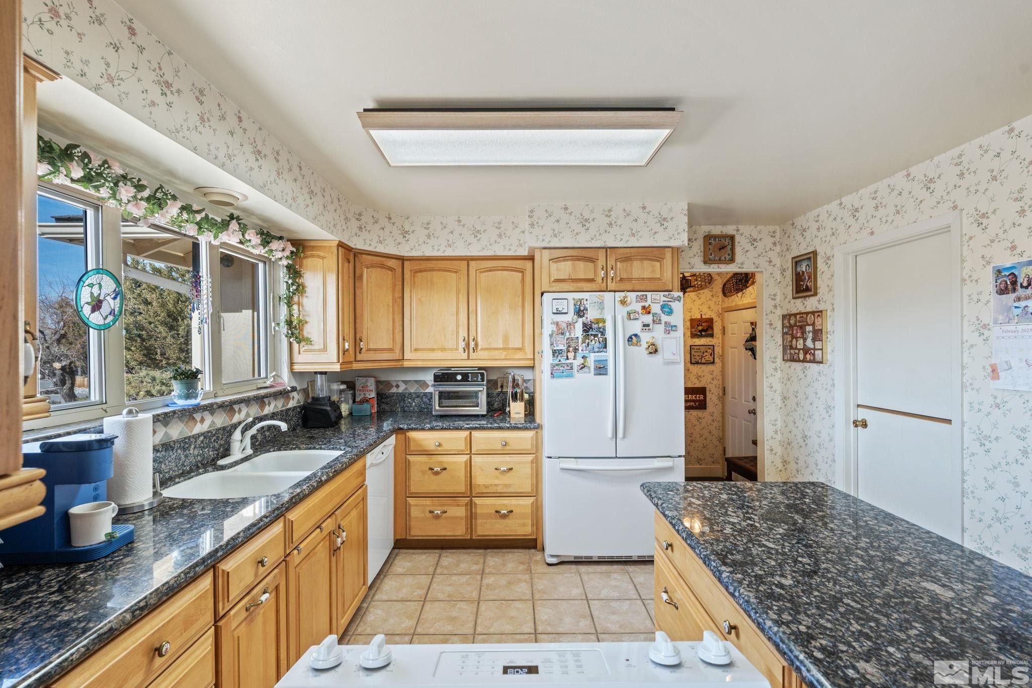 14440 Rim Rock Drive Reno, NV 89521 - Photo 5 of 39 a kitchen with stainless steel appliances granite countertop a sink stove and refrigerator