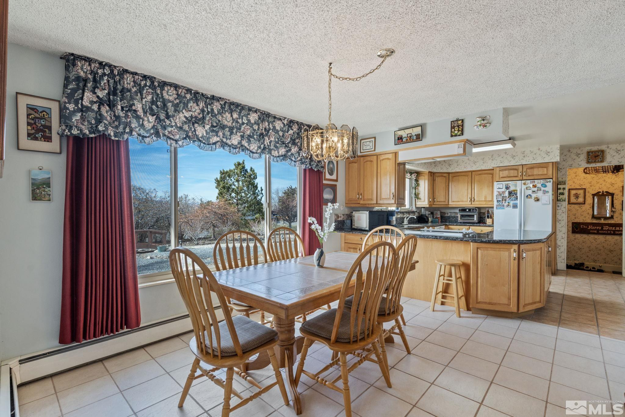 14440 Rim Rock Drive Reno, NV 89521 - Photo 9 of 39 a dining room with furniture and a chandelier