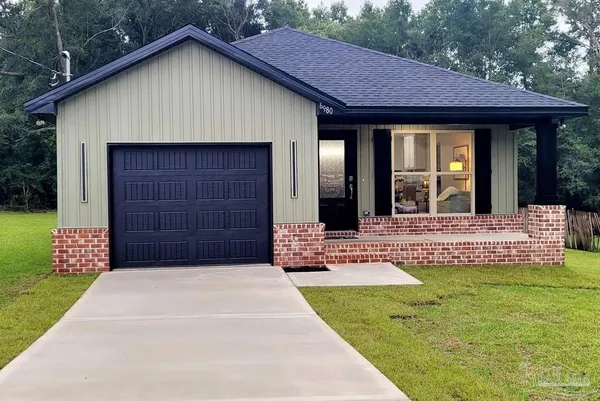 a living room with stainless steel appliances furniture a fireplace a flat screen tv and view kitchen