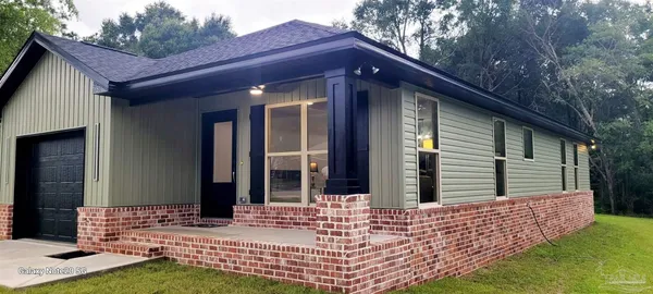 a kitchen with stainless steel appliances granite countertop a sink a stove a refrigerator cabinets and a dining table