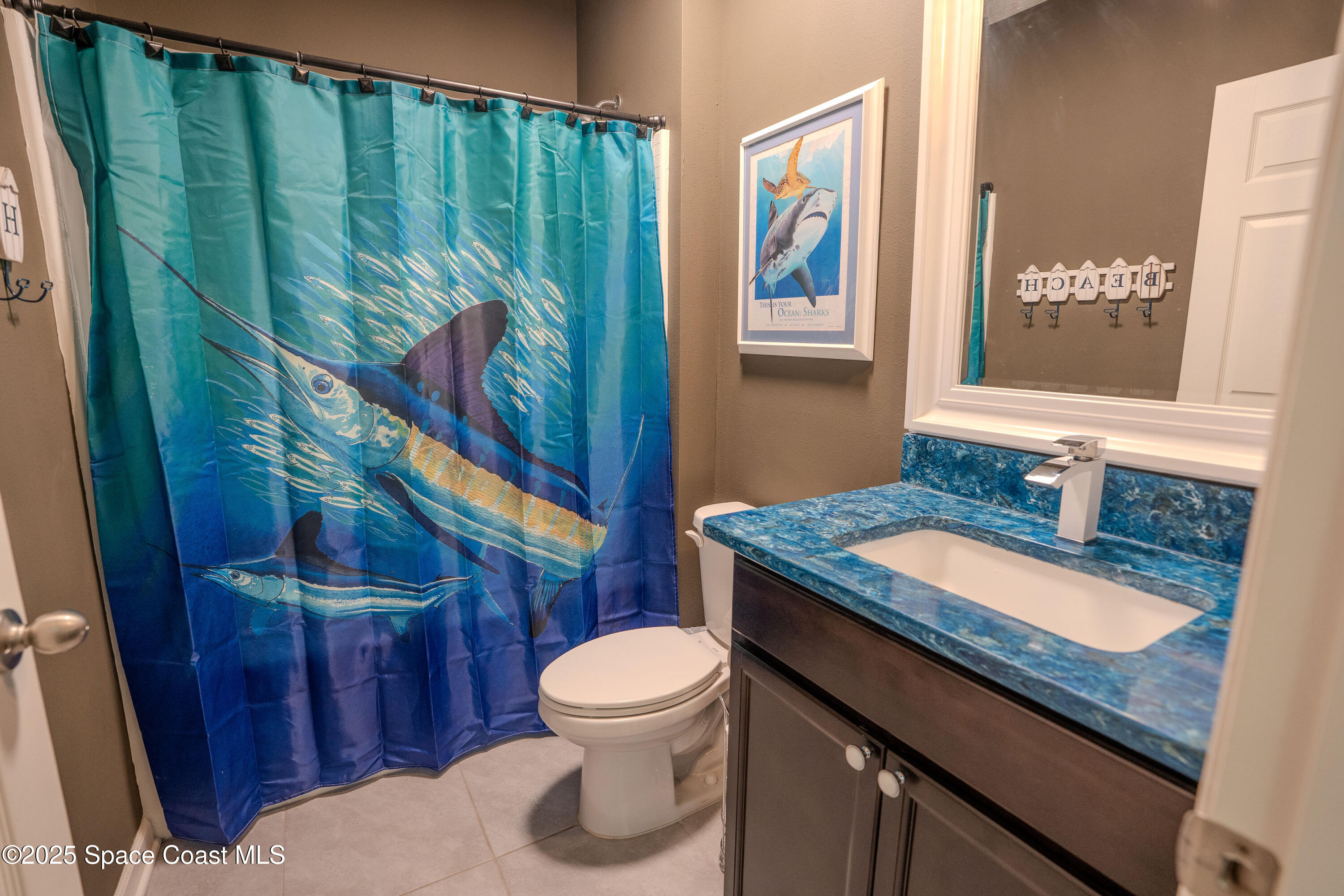 3409 Burrowing Owl Mims, FL 32754 - Photo 17 of 36 a bathroom with a granite countertop toilet sink and mirror