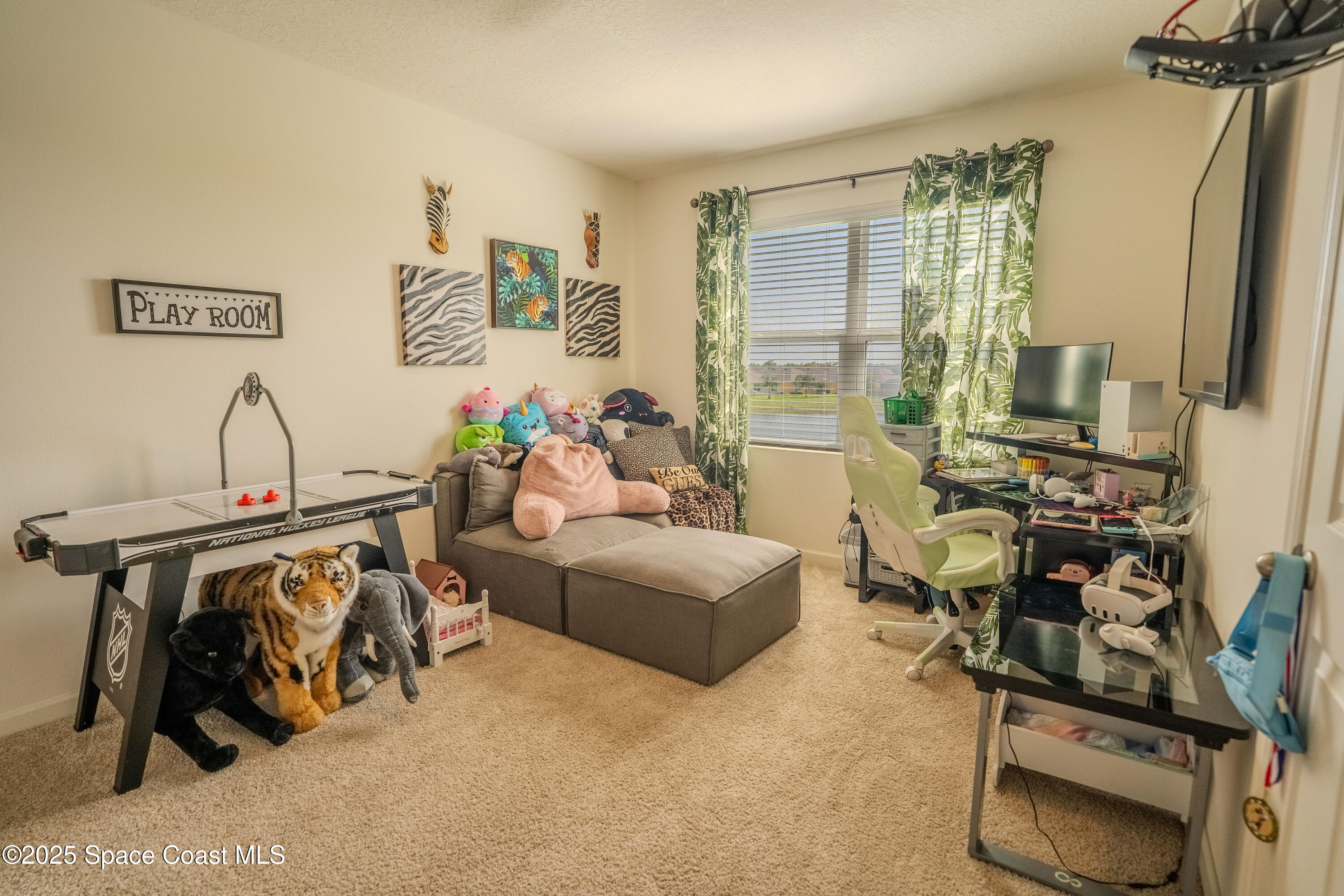 3409 Burrowing Owl Mims, FL 32754 - Photo 27 of 36 a living room with furniture a flat screen tv and gym equipment